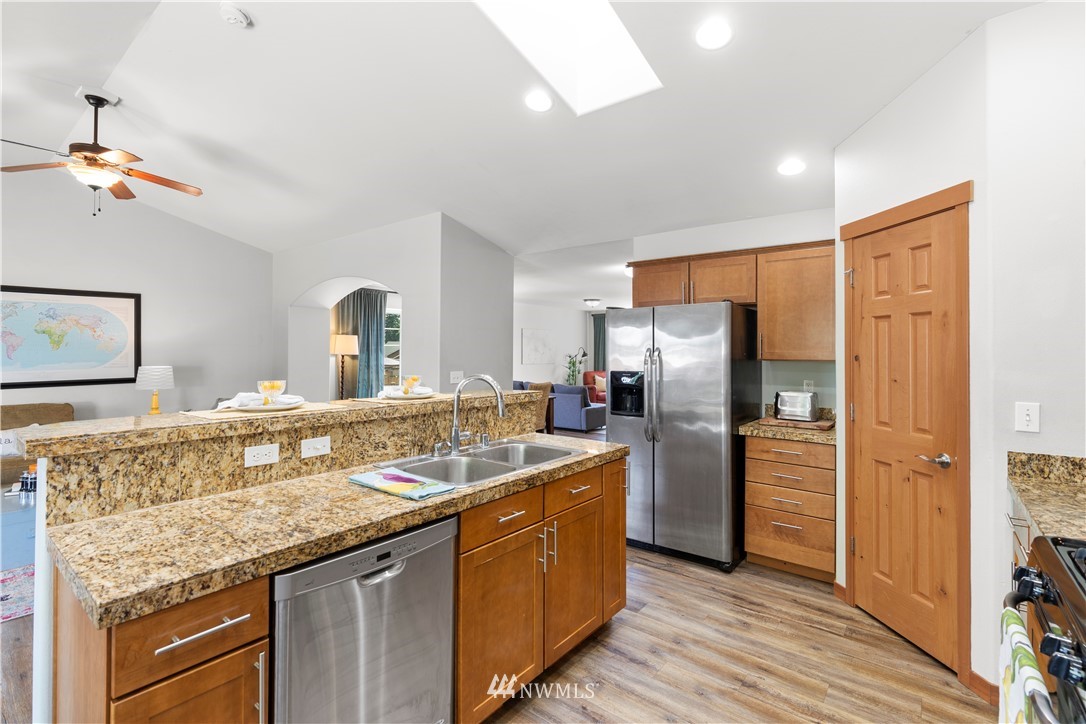 20815 9th Drive Southeast Bothell, WA 98021 - Photo 5 of 23 a kitchen with stainless steel appliances granite countertop a sink refrigerator and cabinets