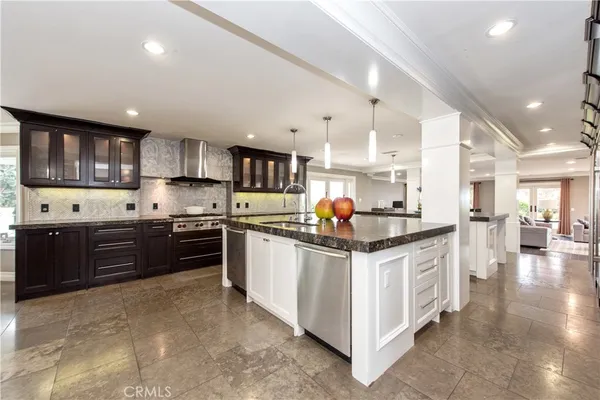 a kitchen with stainless steel appliances kitchen island granite countertop a table and chairs in it