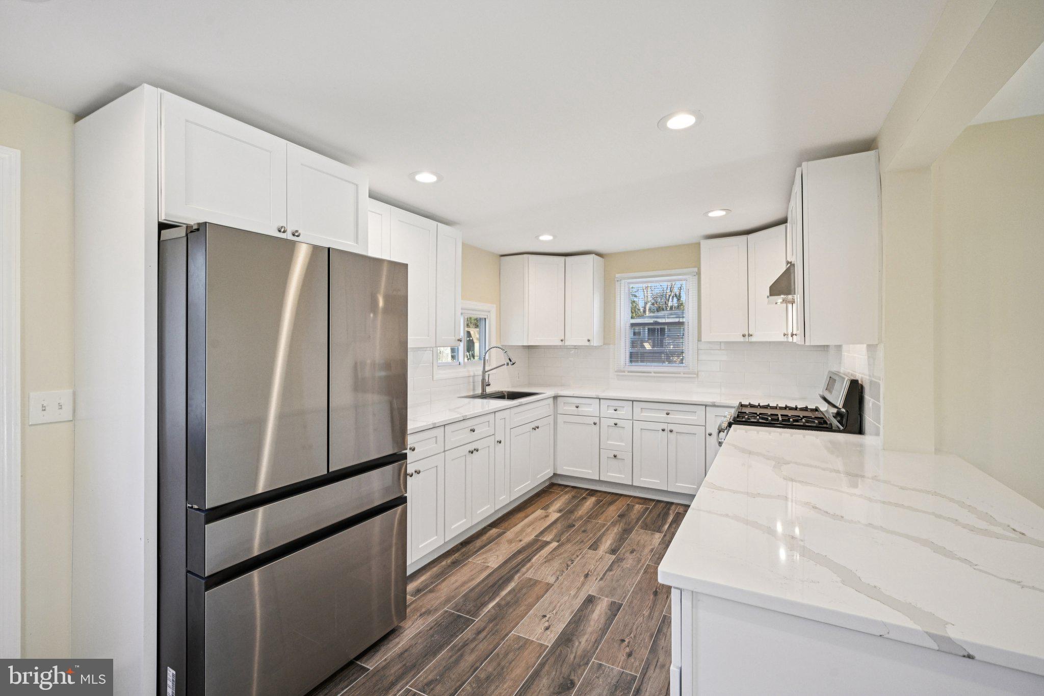 195 Chews Landing Road Clementon, NJ 08021 - Photo 14 of 48 a kitchen with white cabinets and stainless steel appliances