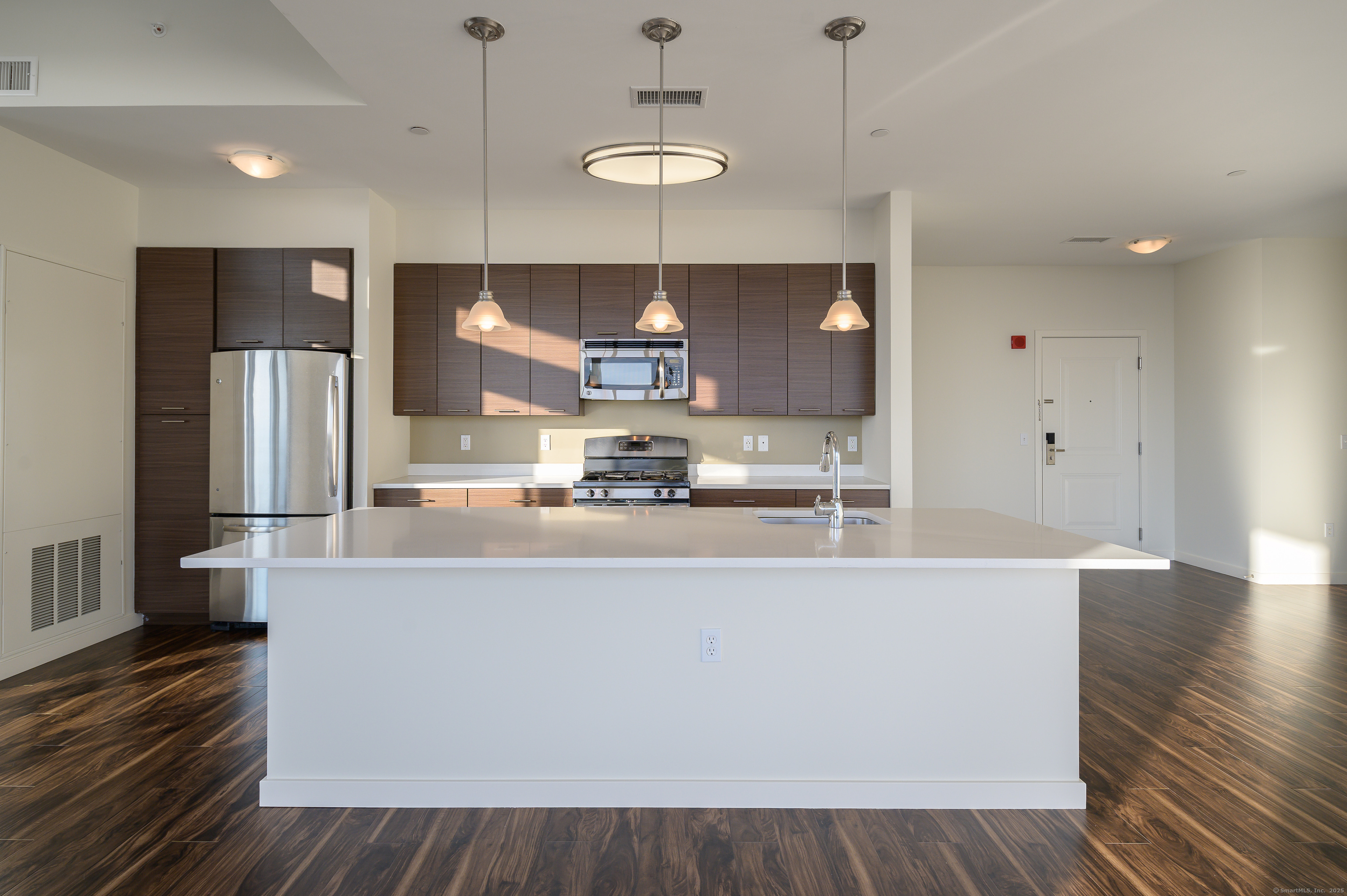 1 Harbor Point Road, Unit 1 Stamford, CT 06902 - Photo 7 of 23 a large kitchen with stainless steel appliances a large counter top a refrigerator a sink and a stove