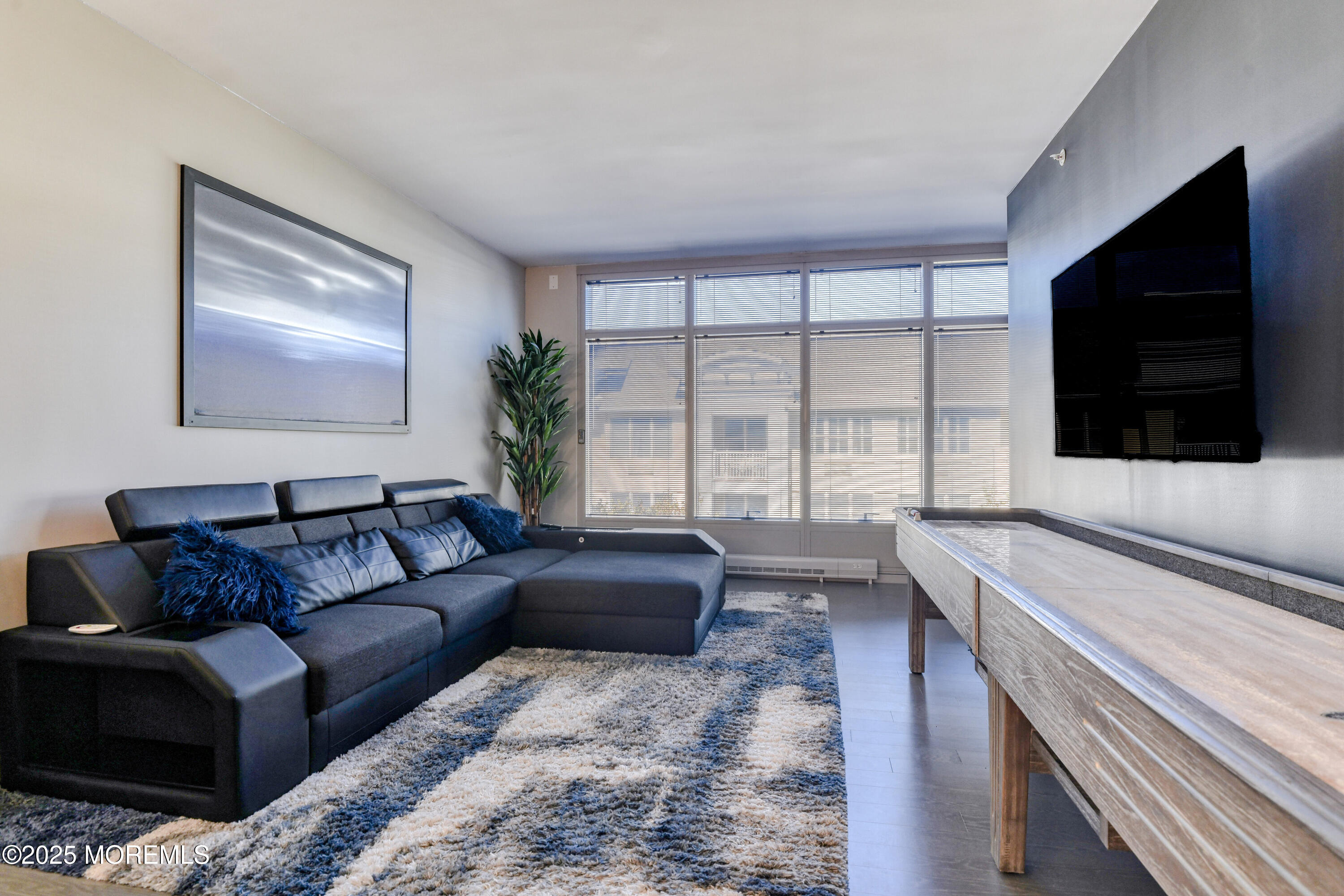 30 Melrose Terrace, Unit 303 Long Branch, NJ 07740 - Photo 15 of 54 a living room with furniture a flat screen tv and a large window