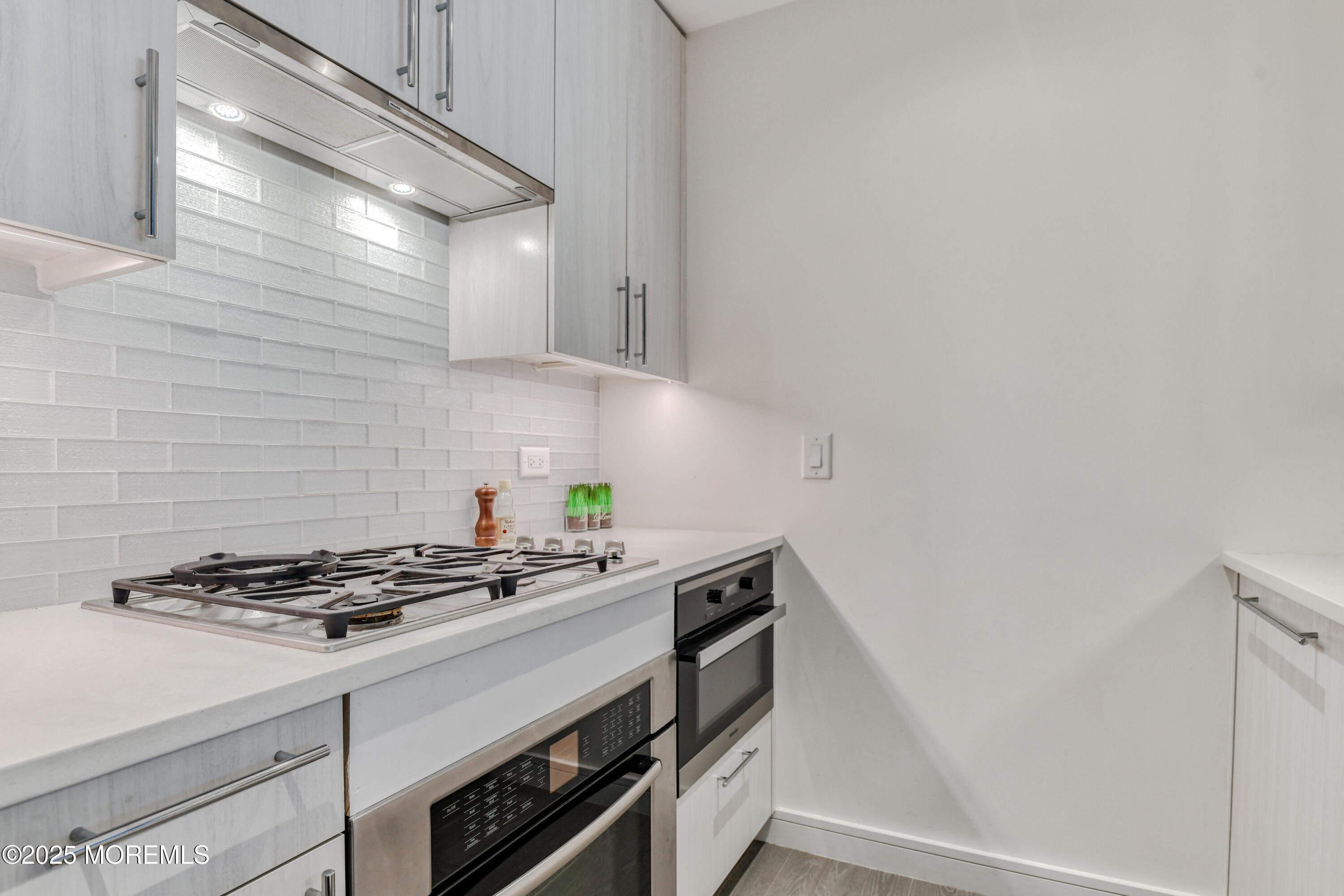30 Melrose Terrace, Unit 303 Long Branch, NJ 07740 - Photo 10 of 54 a kitchen with granite countertop a stove and a white cabinets