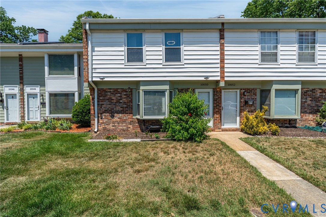 10050 Purcell Road Richmond, VA 23228 - Photo 1 of 26 a view of a house with brick walls and a yard with plants