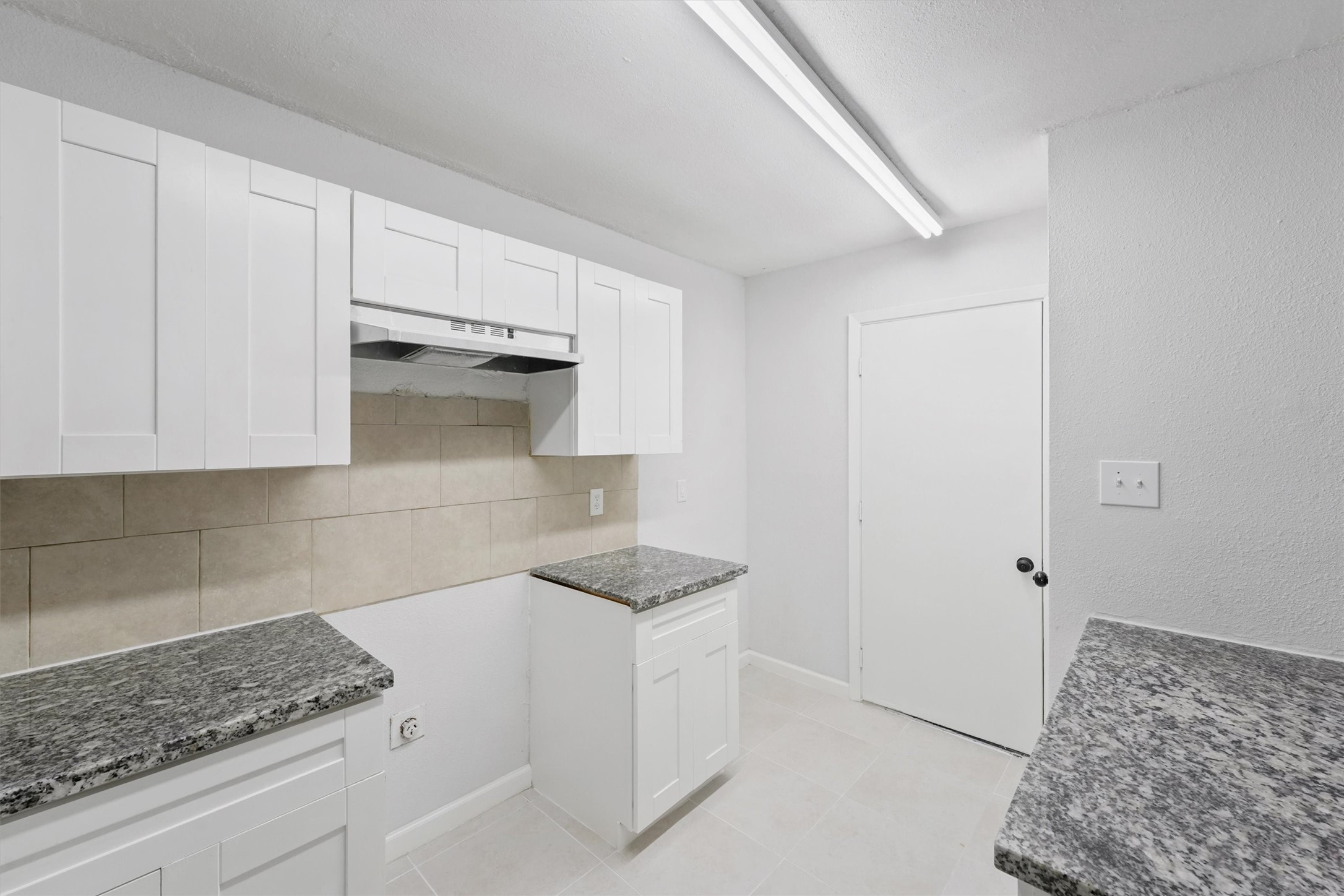 23311 Pebworth Place Spring, TX 77373 - Photo 9 of 24 a kitchen with granite countertop white cabinets and white appliances