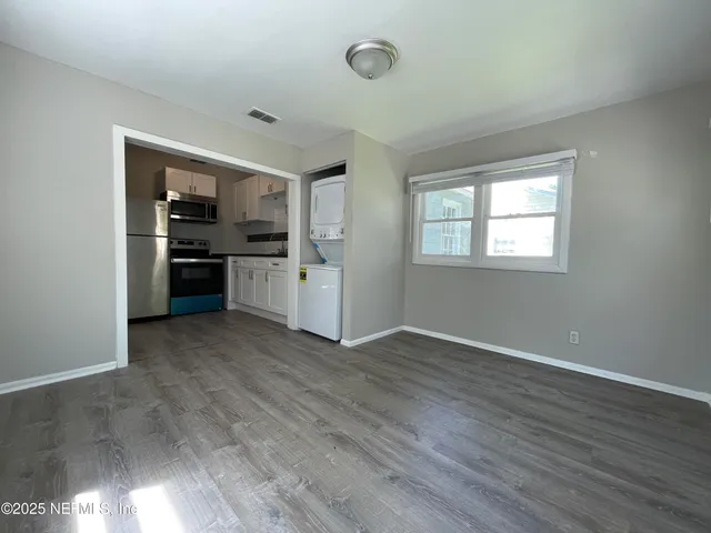 an empty room with windows and cabinet