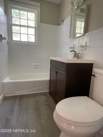 a bathroom with a sink a toilet a window and mirror