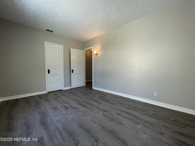 a view of an empty room with wooden floor