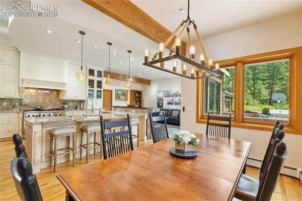 a kitchen with stainless steel appliances kitchen island granite countertop a table and chairs in it