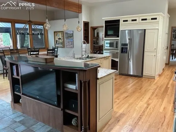 a kitchen with stainless steel appliances granite countertop a sink and a refrigerator