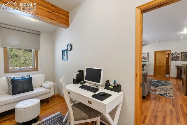 a view of a workspace with furniture and a window