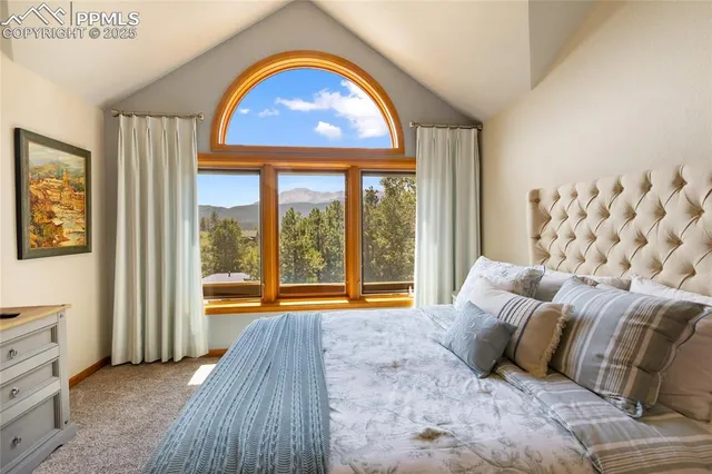 a bedroom with a bed and a large window with outer view