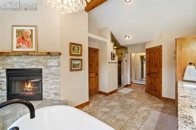 a living room with stainless steel appliances furniture a fireplace and a rug