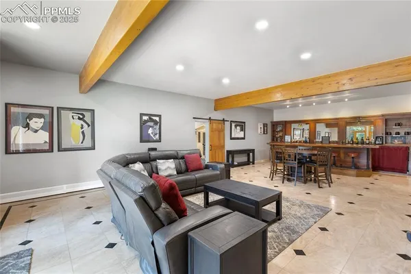 a living room with furniture and view of kitchen
