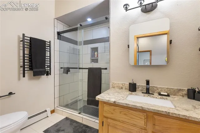 a bathroom with a granite countertop sink a mirror and shower