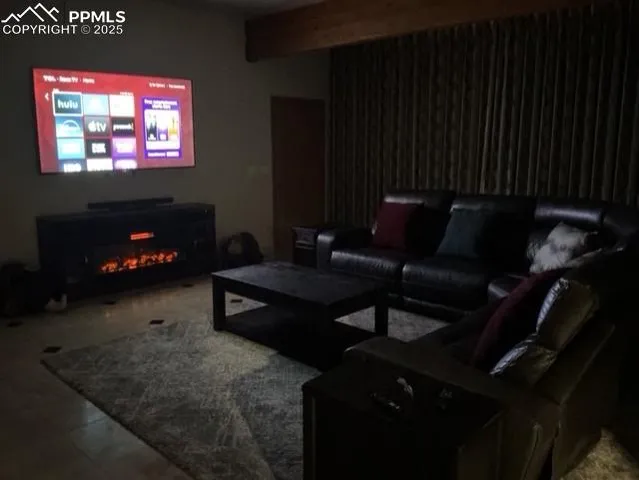 a living room with furniture a flat screen tv and a fireplace