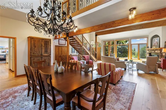 a dining room with furniture a chandelier and wooden floor
