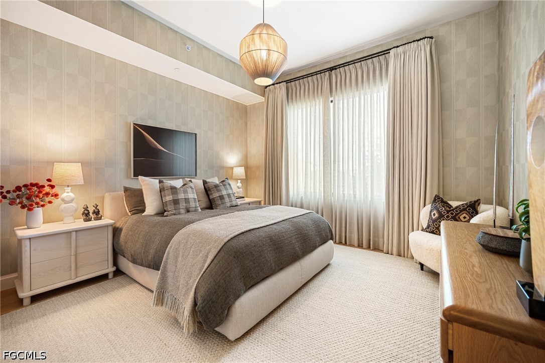 1115 Central Avenue, Unit 443 Naples, FL 34102 - Photo 14 of 40 a spacious bedroom with a bed and a chandelier