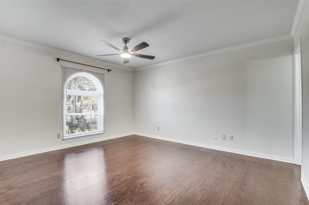 5602 Magnolia Lane Rowlett, TX 75089 - Photo 11 of 24 an empty room with wooden floor chandelier fan and windows