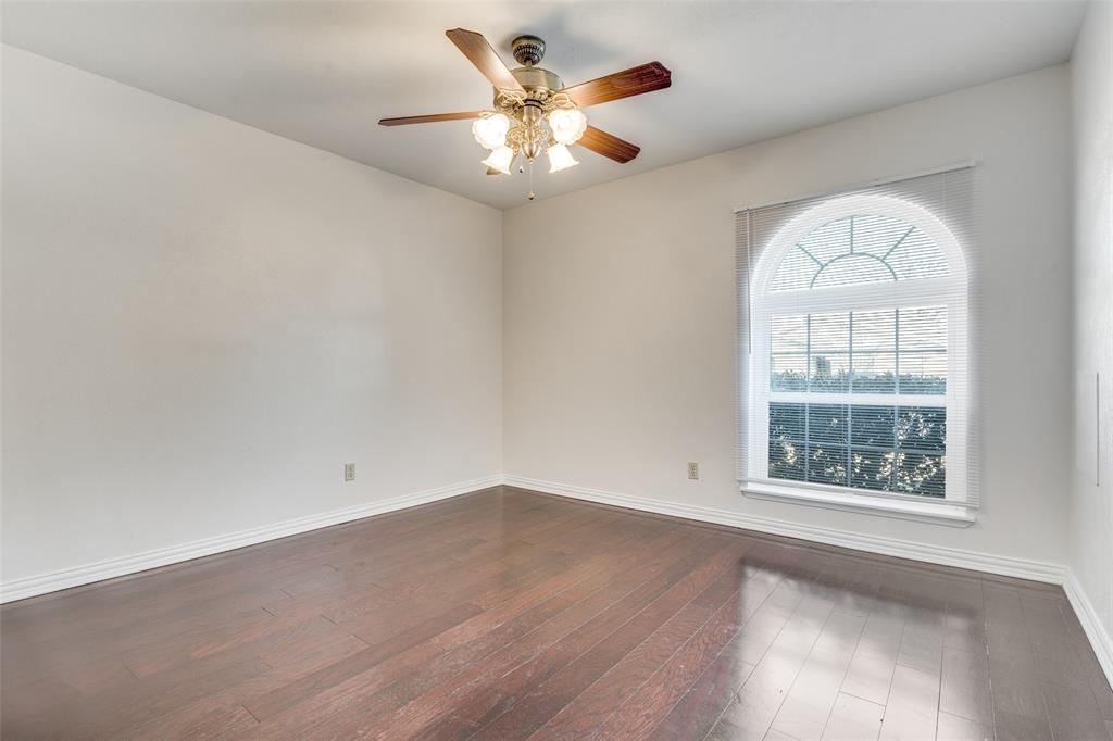 5602 Magnolia Lane Rowlett, TX 75089 - Photo 15 of 24 an empty room with wooden floor chandelier fan and windows