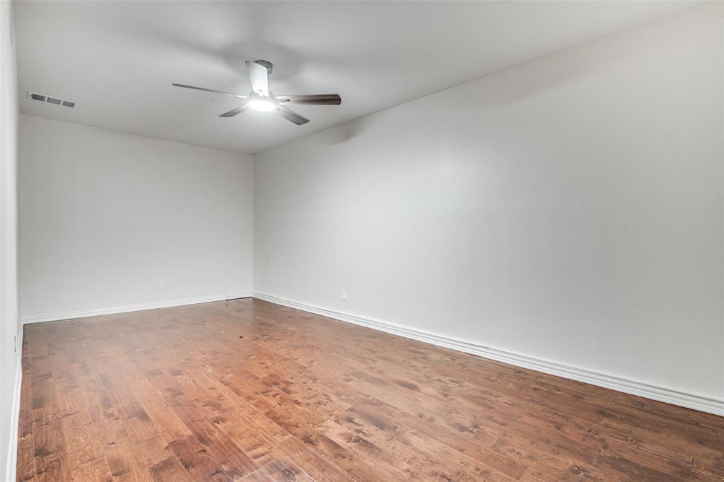 5602 Magnolia Lane Rowlett, TX 75089 - Photo 16 of 24 an empty room with a chandelier fan and windows