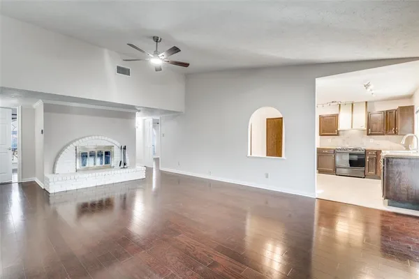 a view of an empty room with window and wooden floor