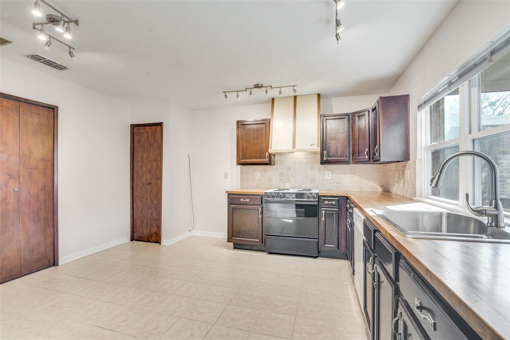5602 Magnolia Lane Rowlett, TX 75089 - Photo 6 of 24 a kitchen with stainless steel appliances granite countertop a sink stove and refrigerator