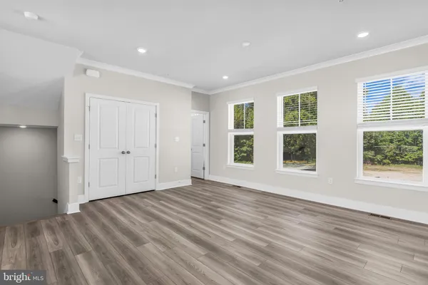 a kitchen with granite countertop a white stove top oven and white cabinets with wooden floor