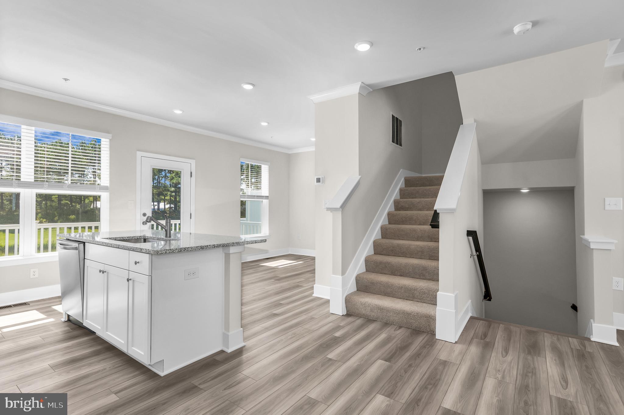 2110 Winterberry Lane Cambridge, MD 21613 - Photo 12 of 46 a kitchen with granite countertop a white stove top oven and white cabinets with wooden floor