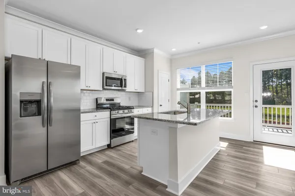a kitchen with stainless steel appliances a refrigerator sink and microwave