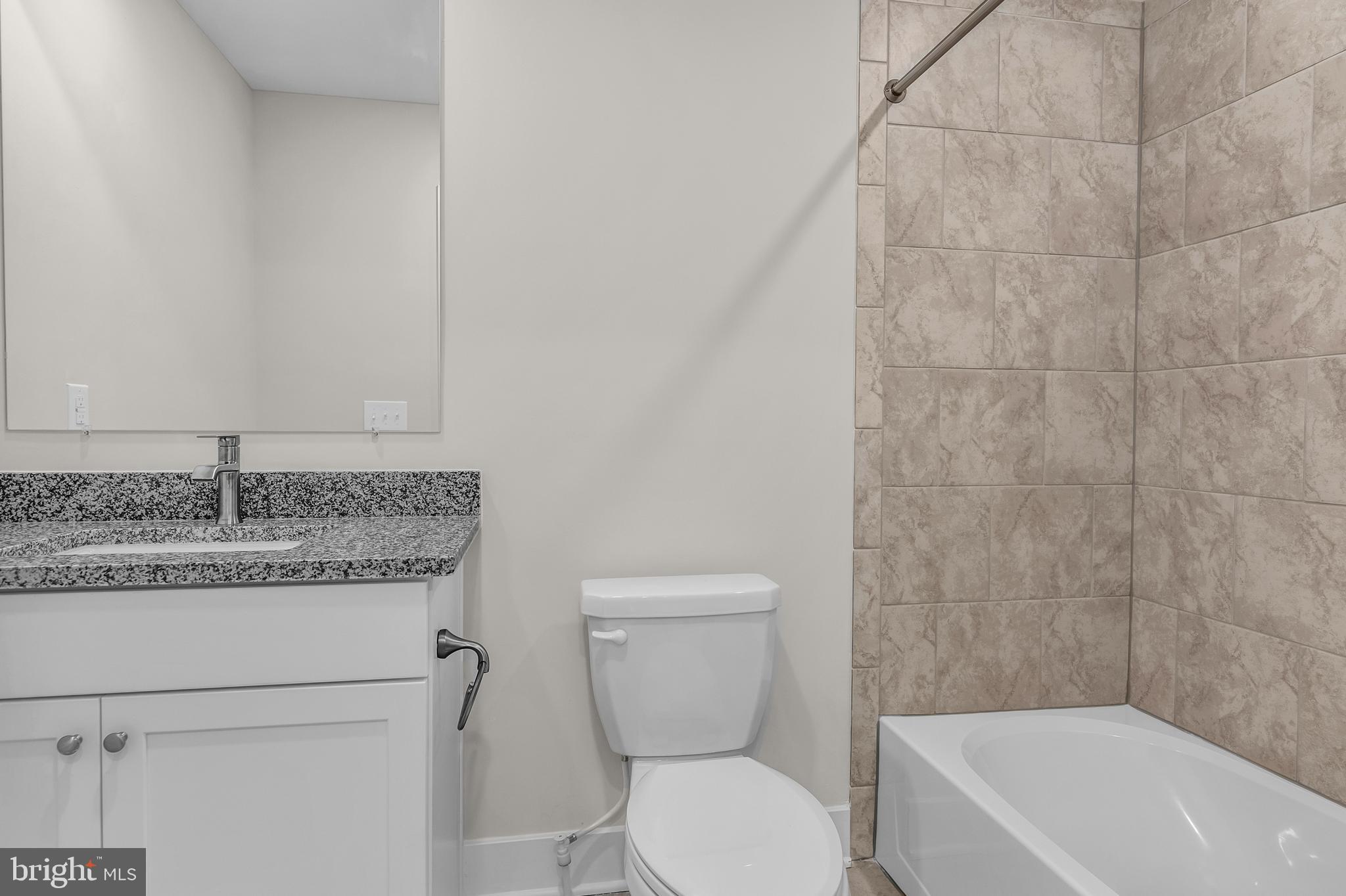 2110 Winterberry Lane Cambridge, MD 21613 - Photo 35 of 46 a bathroom with a granite countertop toilet a sink and bathtub