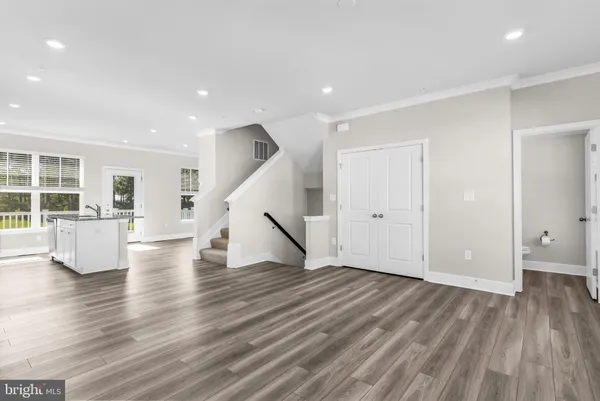 a view of an empty room with wooden floor and windows