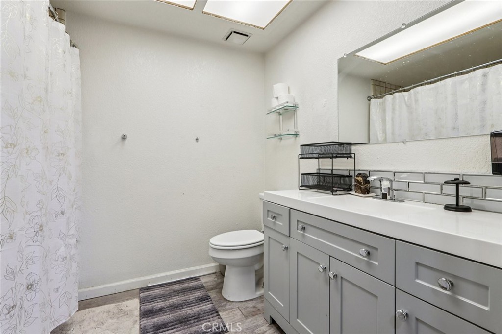 14057 Crow Road Apple Valley, CA 92307 - Photo 16 of 33 a bathroom with a granite countertop toilet sink and mirror