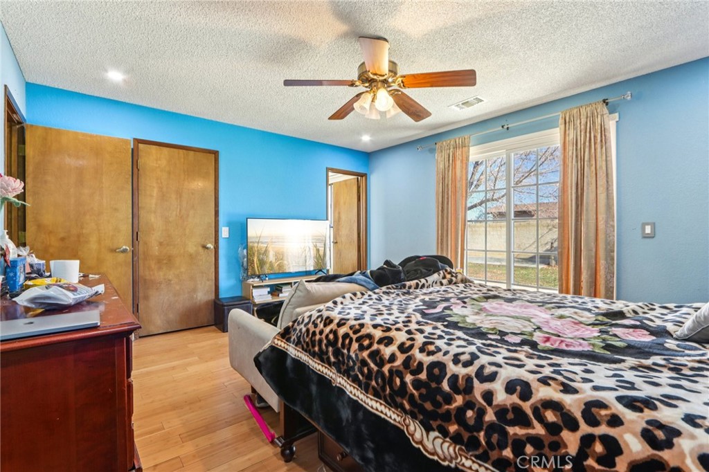 14057 Crow Road Apple Valley, CA 92307 - Photo 19 of 33 a bedroom with a bed and a chandelier