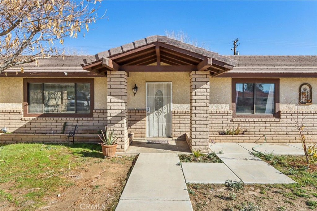 14057 Crow Road Apple Valley, CA 92307 - Photo 6 of 33 a front view of a house with a yard