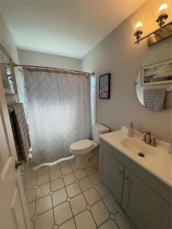 a bathroom with a sink mirror vanity and toilet
