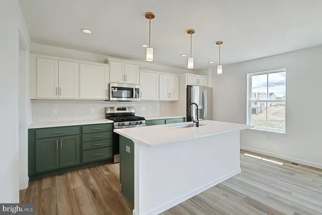 a kitchen with kitchen island a sink stainless steel appliances and cabinets