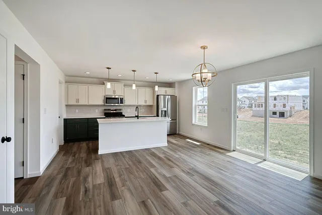 a view of kitchen with granite countertop refrigerator oven a sink dishwasher and a fireplace with wooden floor