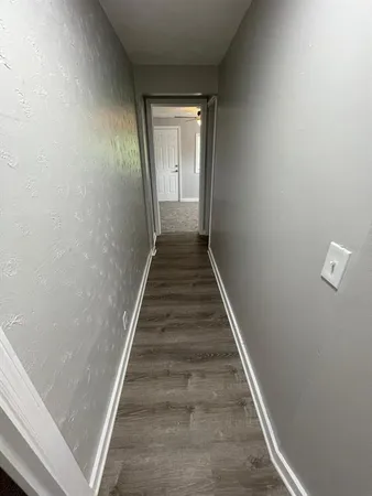 a view of a hallway with wooden floor and staircase