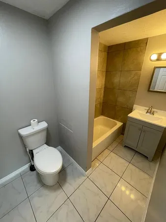 a bathroom with a sink toilet a mirror and bathtub