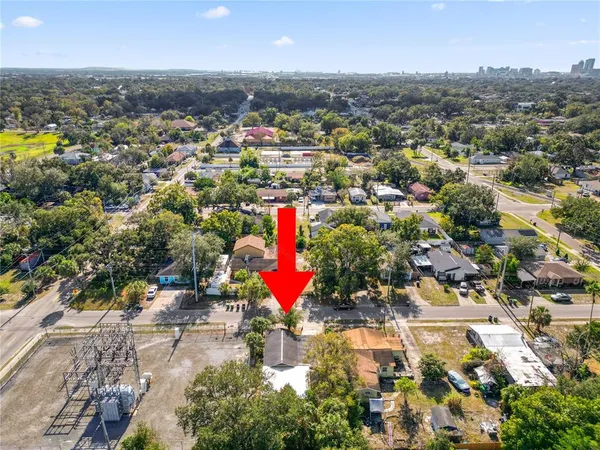 an aerial view of a house with swimming pool and large trees
