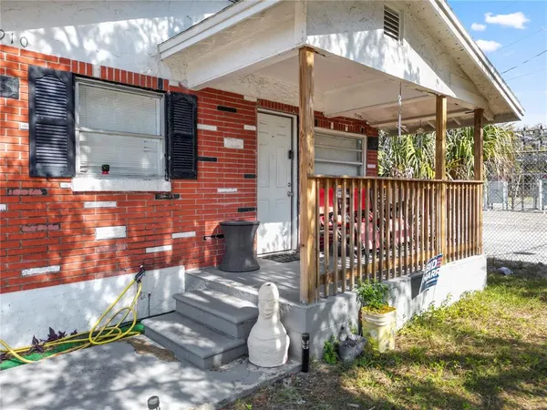 a view of a porch with a table and chairs under an umbrella