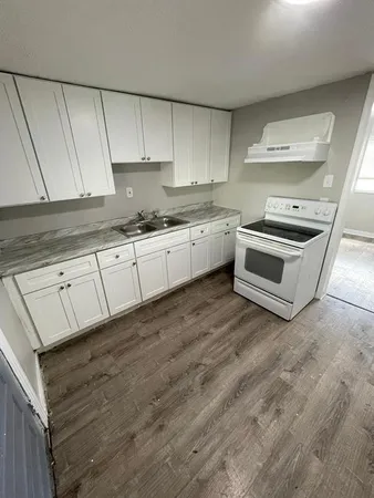a kitchen with granite countertop white cabinets and white appliances