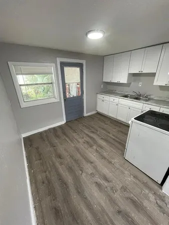 a kitchen with stainless steel appliances granite countertop a sink dishwasher a stove refrigerator and cabinets with wooden floor