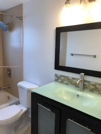 a bathroom with a sink a toilet and mirror