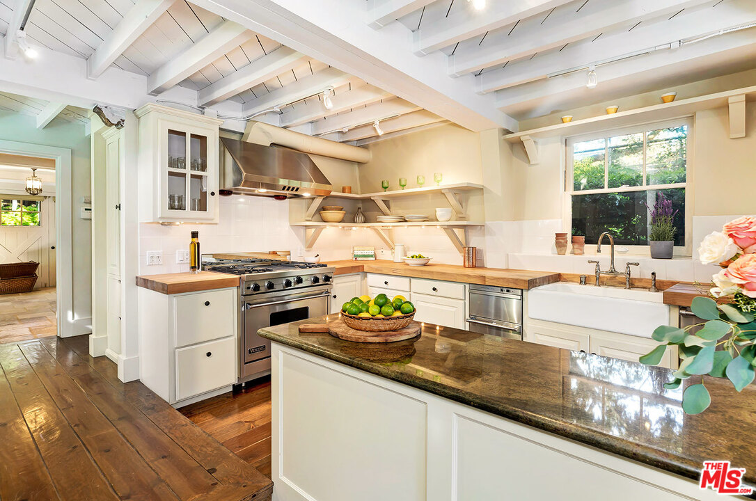689 Brooktree Road Santa Monica, CA 90402 - Photo 16 of 32 a kitchen with granite countertop a stove and white cabinets