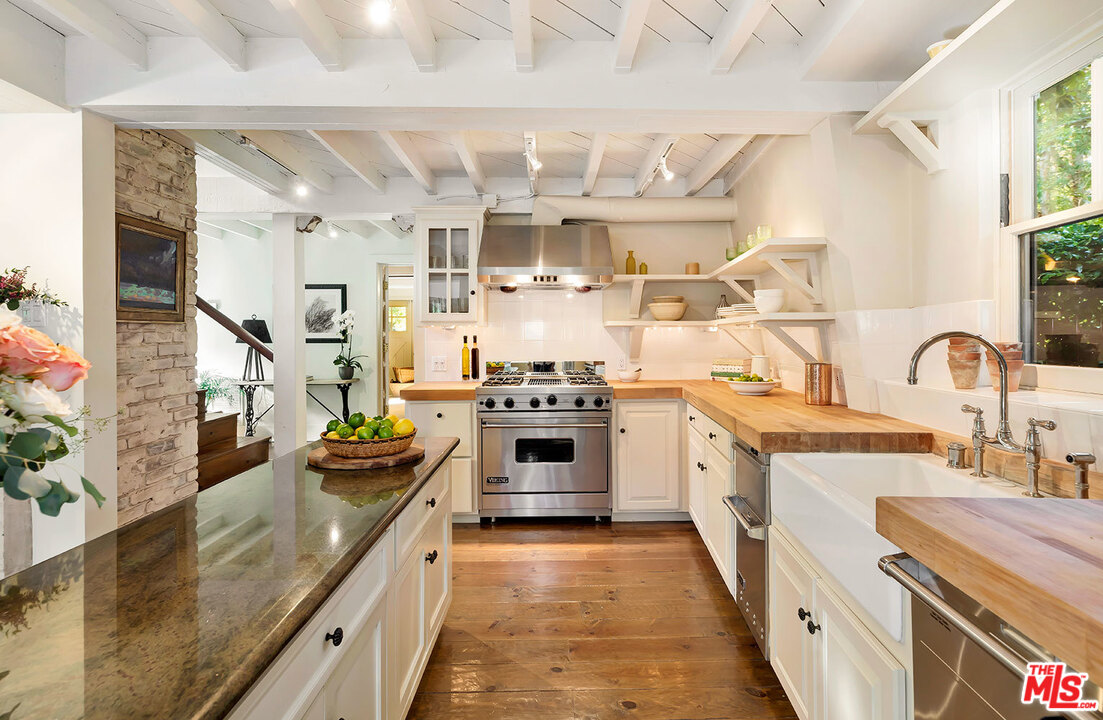 689 Brooktree Road Santa Monica, CA 90402 - Photo 19 of 32 a kitchen with stainless steel appliances granite countertop a stove and a sink