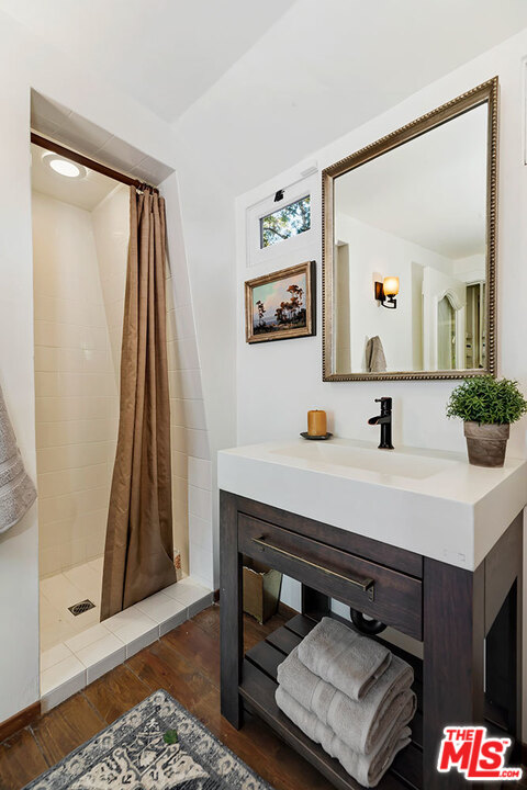 689 Brooktree Road Santa Monica, CA 90402 - Photo 22 of 32 a bathroom with a sink a mirror and a shower