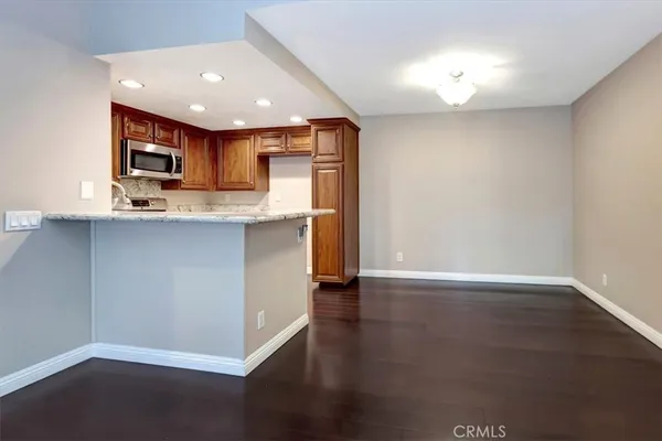 a view of kitchen with stainless steel appliances granite countertop a sink and cabinets
