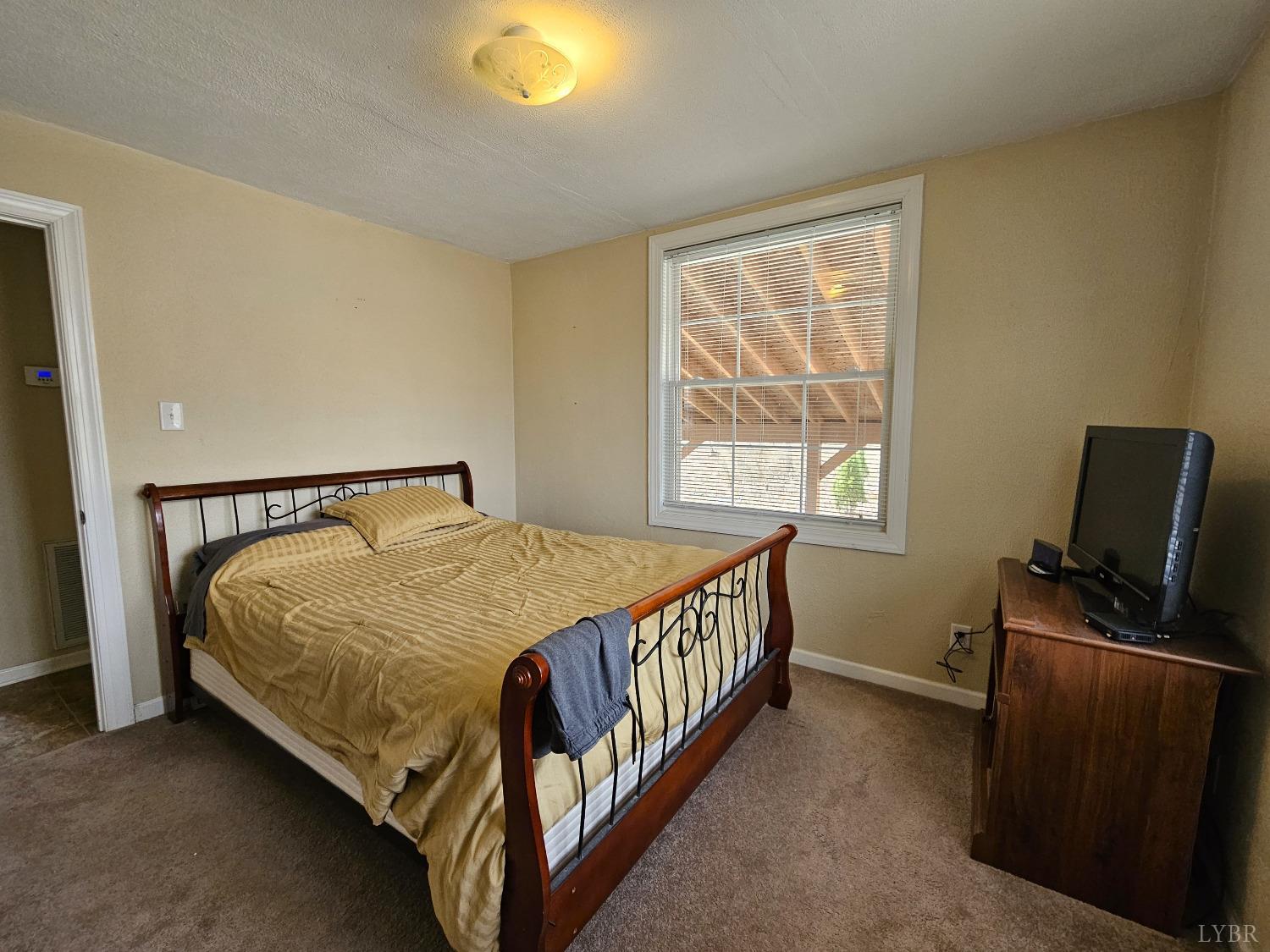 3190 Five Forks Road Pamplin, VA 23958 - Photo 17 of 31 a bed sitting in a bedroom next to a window