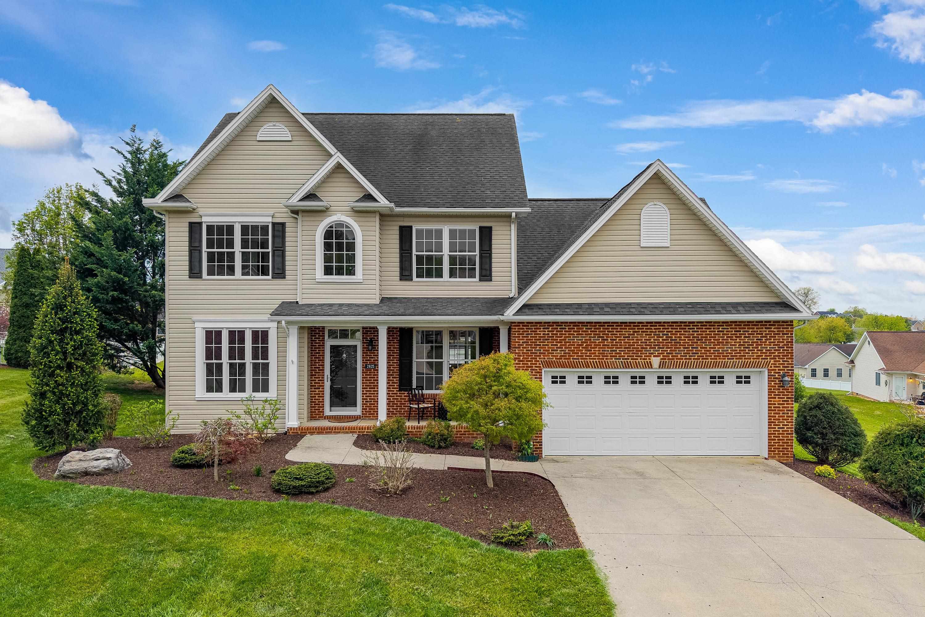 The front view of this lovely, two-story home, features a concrete driveway, cul-de-sac location, front porch, two car garage, and mature landscaping!